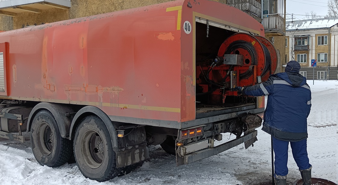 Каналопромывочная машина и работник прочищают засор в канализационной системе в Белозерске